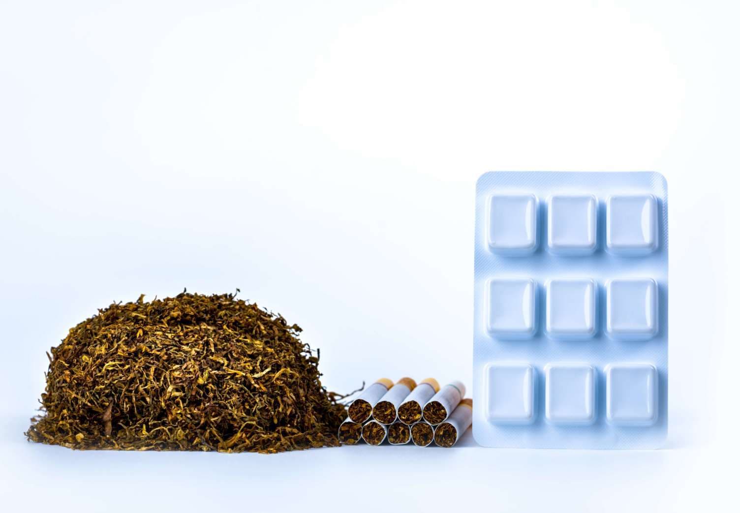 Nicotine chewing gum in blister pack near pile of cigarette. Quit smoking by use nicotine gum for relief of nicotine withdrawal symptoms. Medicine for giving up smoking. World no tobacco day concept.