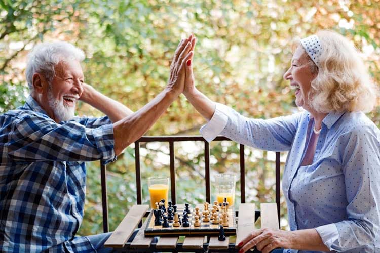 Senior couple playing chess at home