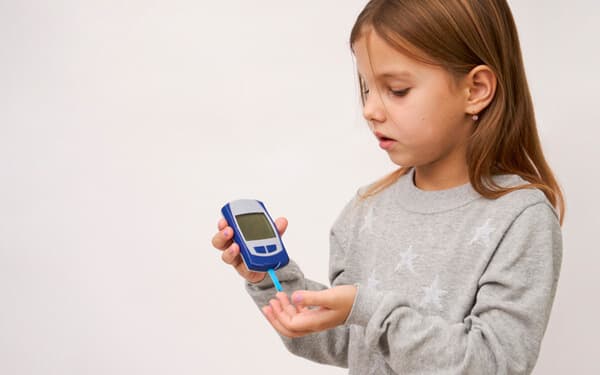 Diabetes in children's concept. Little girl checking blood sugar level