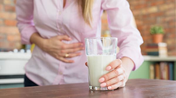 Woman having pain in stomach, feeling sick by drinking milk