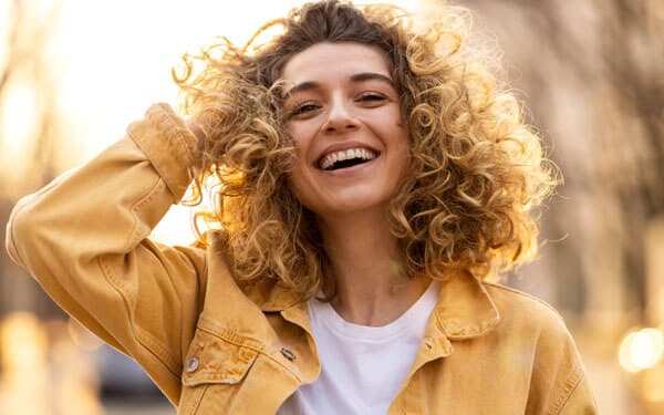 Portrait of young woman with curly hair in the city