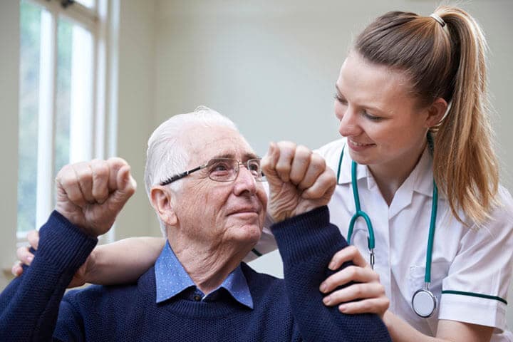 Krankenschwester beurteilt Schlaganfallopfer, indem sie die Arme hebt