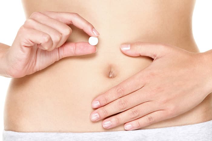 Frau hälte Pille danach vor ihren Bauch