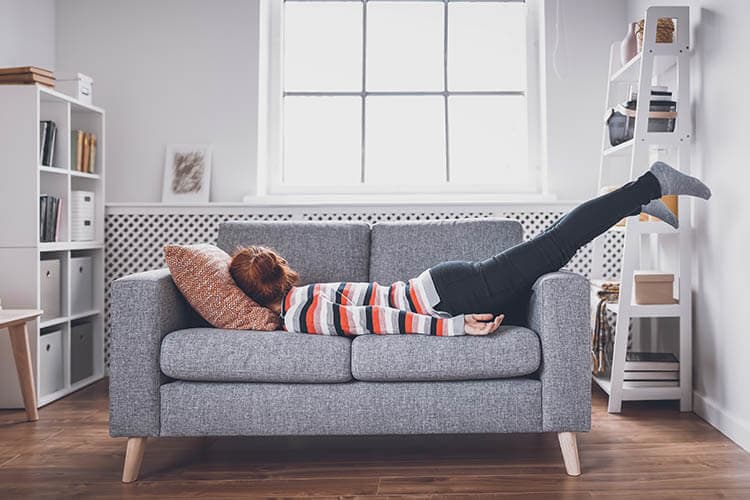 Tired woman lying on the sofa after hard day. Concept of boredom, depression and fatigue.