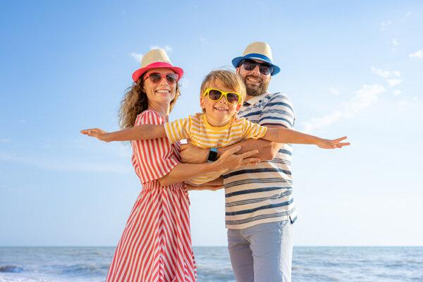 Glückliche Familie hat Spass während den Ferien am sonnigen Strand